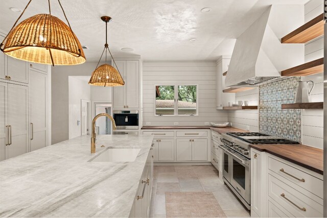 4622 Lake View Dr, Austin, TX 78731 - kitchen with stainless steel appliances, a sink, open shelves, exhaust hood, and white cabinetry