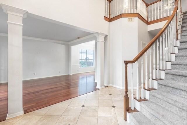10701 Redmond Rd, Austin, TX 78739 - tiled entryway featuring decorative columns, ornamental molding, and stairs