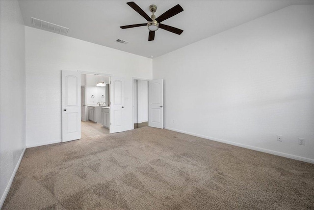 1013 S San Marcos St, Manor, TX 78653 - unfurnished bedroom with light carpet, connected bathroom, lofted ceiling, and a ceiling fan