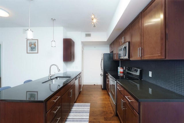 3016 Guadalupe St Unit 202, Austin, TX 78705 - kitchen featuring stainless steel appliances, a sink, a peninsula, dark wood-type flooring, and backsplash