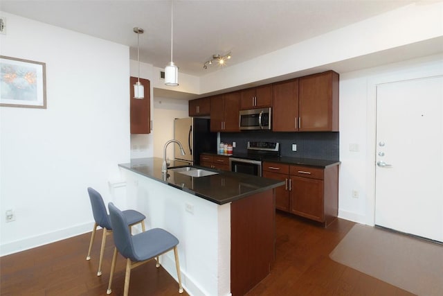 3016 Guadalupe St Unit 202, Austin, TX 78705 - kitchen featuring appliances with stainless steel finishes, dark countertops, a sink, and dark wood finished floors