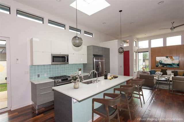 420 Starlight Village Loop Unit 17, Leander, TX 78641 - kitchen featuring stainless steel appliances, modern cabinets, a sink, dark wood-style flooring, and a breakfast bar area