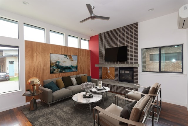 420 Starlight Village Loop Unit 17, Leander, TX 78641 - living room featuring an AC wall unit, ceiling fan, wood finished floors, a tiled fireplace, and baseboards