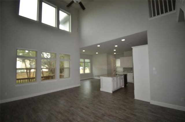 121 Bright Valley Way, Austin, TX 78737 - unfurnished living room with a ceiling fan, a high ceiling, baseboards, dark wood finished floors, and recessed lighting