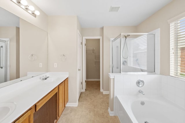 117 Kerley Dr, Hutto, TX 78634 - full bath featuring double vanity, a stall shower, a bath, tile patterned floors, and a walk in closet