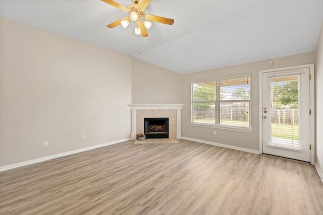117 Kerley Dr, Hutto, TX 78634 - unfurnished living room featuring light wood-type flooring, baseboards, ceiling fan, a fireplace, and vaulted ceiling
