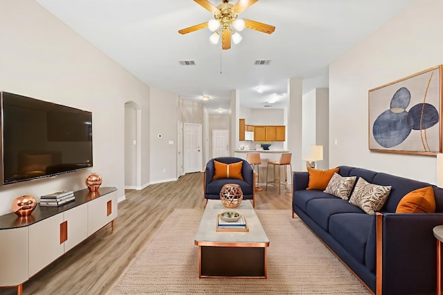 117 Kerley Dr, Hutto, TX 78634 - living area featuring a ceiling fan, light wood finished floors, baseboards, and arched walkways