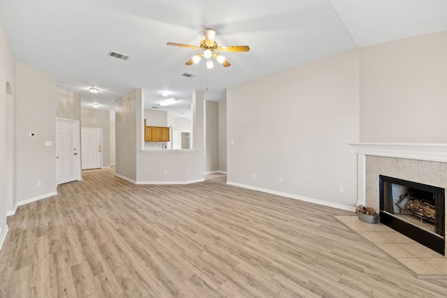 117 Kerley Dr, Hutto, TX 78634 - unfurnished living room featuring a ceiling fan, light wood-style floors, a tile fireplace, and baseboards