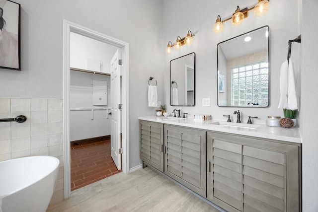 15901 Double Eagle Dr, Austin, TX 78717 - bathroom featuring double vanity, a freestanding bath, a walk in closet, and tile walls