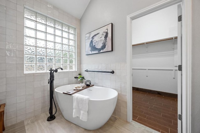 15901 Double Eagle Dr, Austin, TX 78717 - bathroom with a spacious closet, tile walls, a soaking tub, and wainscoting