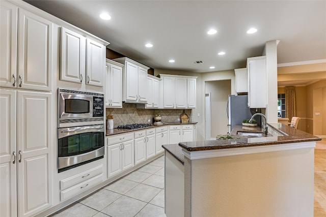 107 Apache Mountain Ln, Georgetown, TX 78633 - kitchen featuring appliances with stainless steel finishes, decorative backsplash, a sink, white cabinetry, and dark stone counters