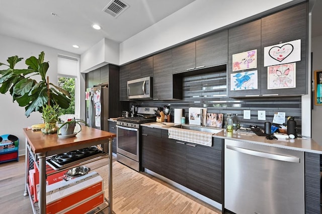 1800 E 4th St Unit 335, Austin, TX 78702 - kitchen featuring stainless steel appliances, light wood-style floors, light countertops, a sink, and modern cabinets