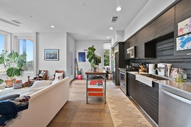 1800 E 4th St Unit 335, Austin, TX 78702 - kitchen featuring stainless steel appliances, modern cabinets, light wood-style floors, healthy amount of natural light, and recessed lighting