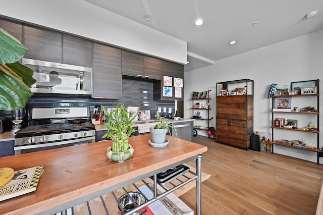 1800 E 4th St Unit 335, Austin, TX 78702 - kitchen featuring appliances with stainless steel finishes, light wood-style flooring, light countertops, tasteful backsplash, and recessed lighting