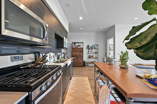 1800 E 4th St Unit 335, Austin, TX 78702 - kitchen with stainless steel appliances, light wood-type flooring, recessed lighting, tasteful backsplash, and light countertops