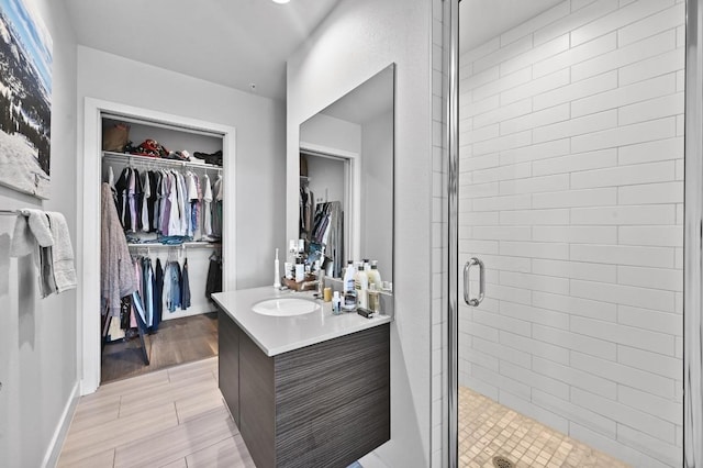 1800 E 4th St Unit 335, Austin, TX 78702 - full bathroom with vanity, a stall shower, a spacious closet, and baseboards