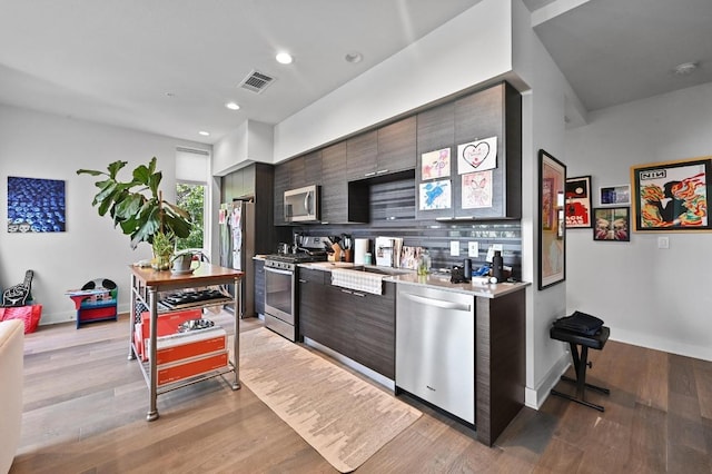 1800 E 4th St Unit 335, Austin, TX 78702 - kitchen with appliances with stainless steel finishes, light countertops, baseboards, recessed lighting, and light wood-type flooring