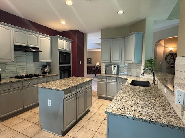 2619 Henley Dr, Round Rock, TX 78681 - kitchen featuring a sink, gray cabinetry, black appliances, under cabinet range hood, and decorative backsplash