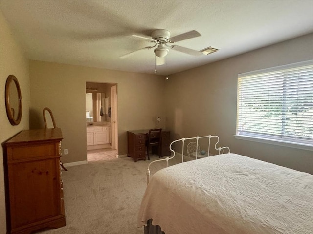 2619 Henley Dr, Round Rock, TX 78681 - bedroom with light carpet, baseboards, a ceiling fan, ensuite bathroom, and a textured ceiling