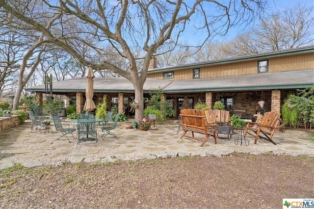 TBD County Road 246, Florence, TX 76527 - back of property featuring an outdoor fire pit, a patio area, and a chimney