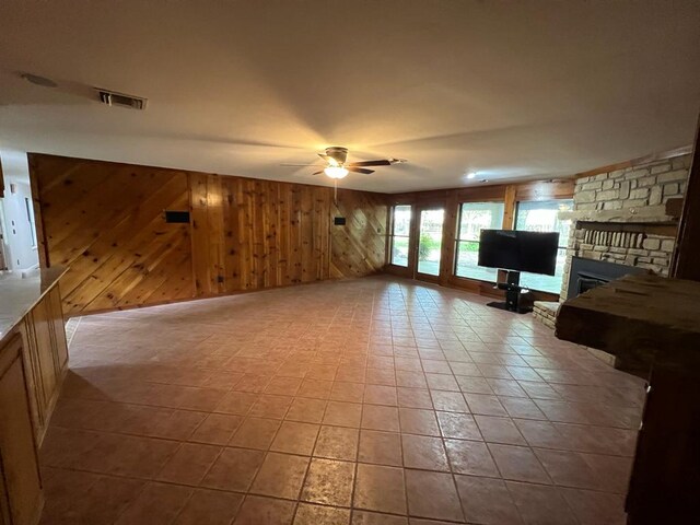 TBD County Road 246, Florence, TX 76527 - unfurnished living room with ceiling fan, wood walls, and a fireplace