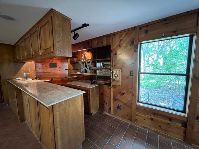 TBD County Road 246, Florence, TX 76527 - kitchen featuring wooden walls, dark tile patterned floors, healthy amount of natural light, and brown cabinetry