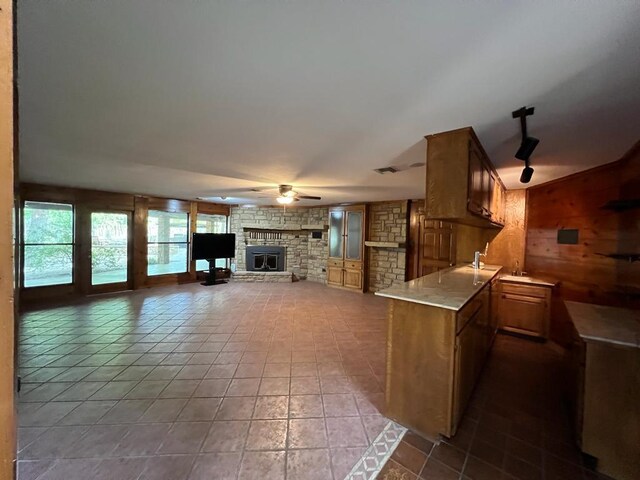 TBD County Road 246, Florence, TX 76527 - kitchen with ceiling fan, light countertops, tile patterned flooring, a fireplace, and wooden walls
