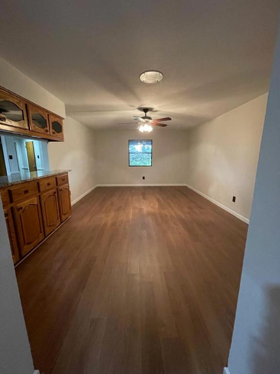 TBD County Road 246, Florence, TX 76527 - unfurnished dining area featuring ceiling fan, dark wood-style flooring, and baseboards