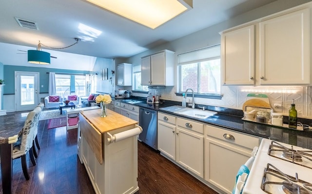 5013 Cleves St, Round Rock, TX 78681 - kitchen with stainless steel dishwasher, white gas range oven, dark wood-style flooring, and white cabinetry
