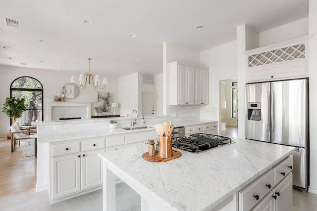 307 Malabar St, Lakeway, TX 78734 - kitchen with stainless steel refrigerator with ice dispenser, a sink, a peninsula, a chandelier, and light stone counters