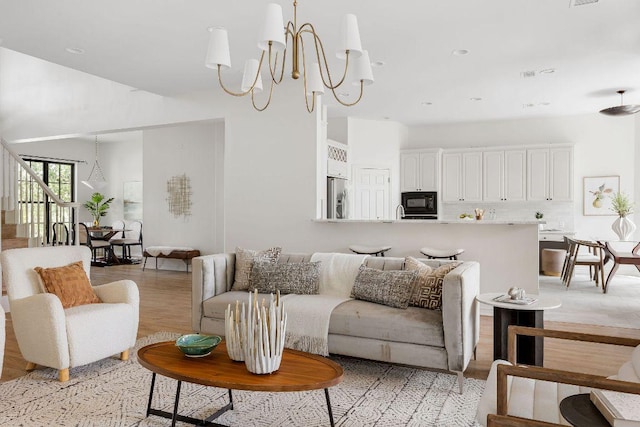 307 Malabar St, Lakeway, TX 78734 - living room featuring light wood-style flooring, a chandelier, a towering ceiling, and recessed lighting