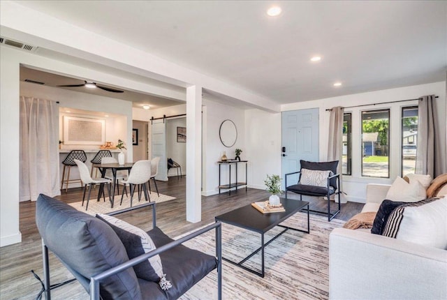 3210 Kay St, Austin, TX 78702 - living room featuring a barn door, wood finished floors, recessed lighting, and ceiling fan