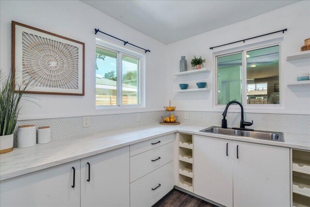 3210 Kay St, Austin, TX 78702 - kitchen with open shelves, tasteful backsplash, white cabinetry, light stone counters, and dark wood-type flooring