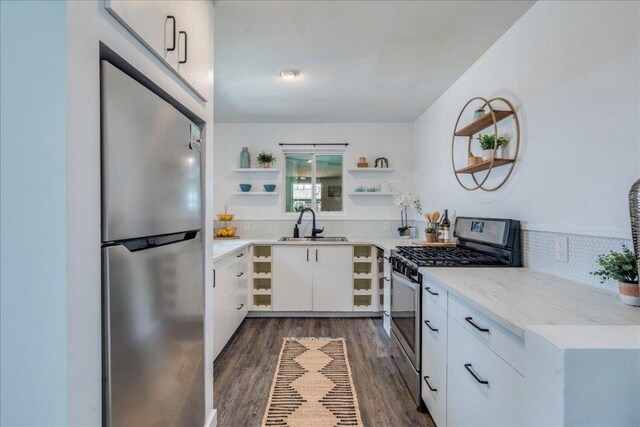 3210 Kay St, Austin, TX 78702 - kitchen with open shelves, stainless steel appliances, dark wood-style floors, white cabinetry, and light stone countertops