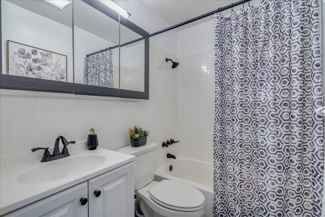 3210 Kay St, Austin, TX 78702 - full bathroom featuring vanity, shower / tub combo with curtain, decorative backsplash, and tile walls