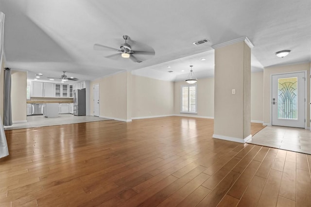 3601 Arrowhead Dr, Austin, TX 78731 - unfurnished living room featuring a ceiling fan, baseboards, light wood-type flooring, and crown molding