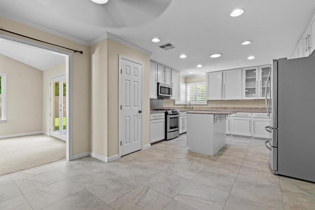 3601 Arrowhead Dr, Austin, TX 78731 - kitchen featuring stainless steel appliances, a kitchen island, crown molding, recessed lighting, and white cabinets