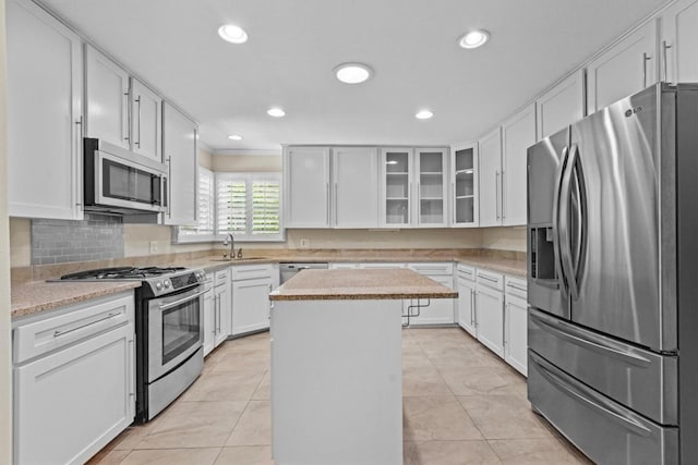 3601 Arrowhead Dr, Austin, TX 78731 - kitchen with appliances with stainless steel finishes, a kitchen island, white cabinetry, and recessed lighting