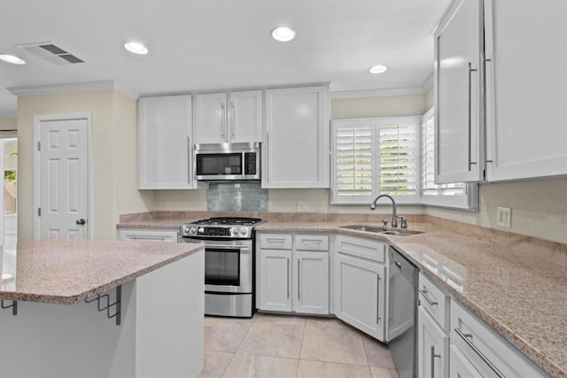 3601 Arrowhead Dr, Austin, TX 78731 - kitchen featuring stainless steel appliances, a sink, crown molding, white cabinets, and light stone countertops