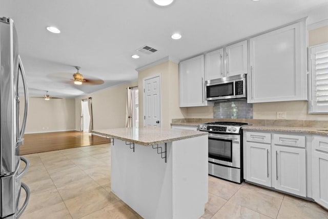 3601 Arrowhead Dr, Austin, TX 78731 - kitchen with stainless steel appliances, light tile patterned floors, a ceiling fan, white cabinets, and recessed lighting