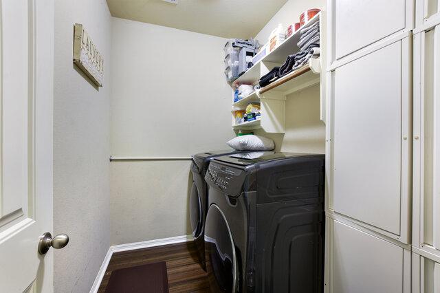 624 Purtis Creek Ln, Georgetown, TX 78628 - laundry room with baseboards, cabinet space, washer and clothes dryer, and wood finished floors