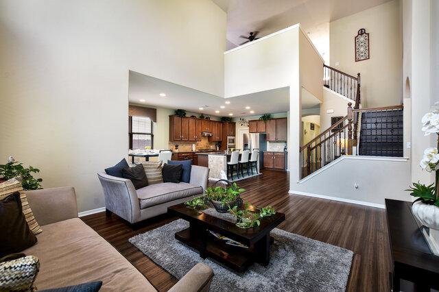 624 Purtis Creek Ln, Georgetown, TX 78628 - living room with dark wood finished floors, baseboards, stairs, ceiling fan, and a towering ceiling