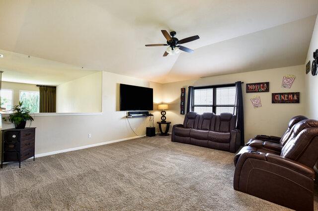 624 Purtis Creek Ln, Georgetown, TX 78628 - carpeted living area featuring lofted ceiling, ceiling fan, plenty of natural light, and baseboards
