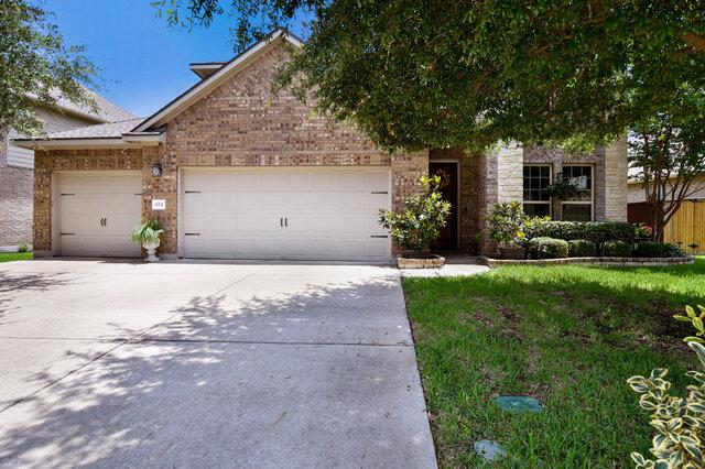 624 Purtis Creek Ln, Georgetown, TX 78628 - obstructed view of property featuring a garage, concrete driveway, and brick siding