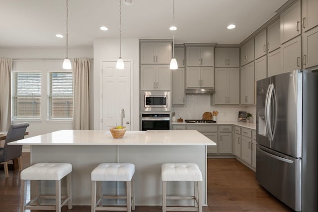 1416 Reprise Bnd, Round Rock, TX 78681 - kitchen featuring appliances with stainless steel finishes, gray cabinetry, backsplash, a kitchen bar, and recessed lighting