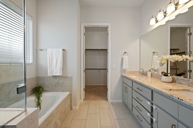 1416 Reprise Bnd, Round Rock, TX 78681 - full bathroom with double vanity, a garden tub, a spacious closet, baseboards, and a shower with shower door