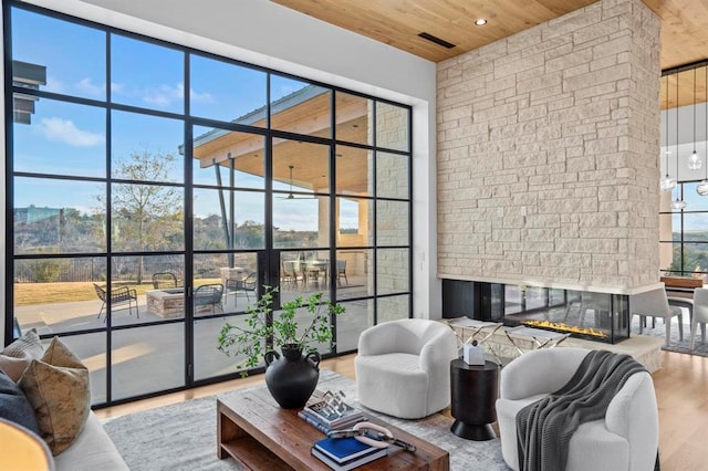 1047 Overlook Pkwy, Horseshoe Bay, TX 78657 - living area with wood ceiling, wood finished floors, a stone fireplace, expansive windows, and recessed lighting