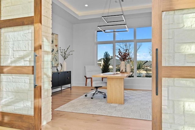 1047 Overlook Pkwy, Horseshoe Bay, TX 78657 - office area featuring wood finished floors, a chandelier, and a tray ceiling