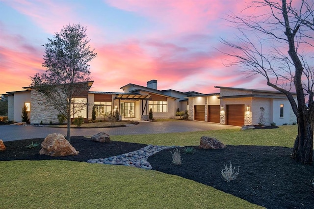 1047 Overlook Pkwy, Horseshoe Bay, TX 78657 - view of front of home featuring stone siding, an attached garage, driveway, a lawn, and a chimney