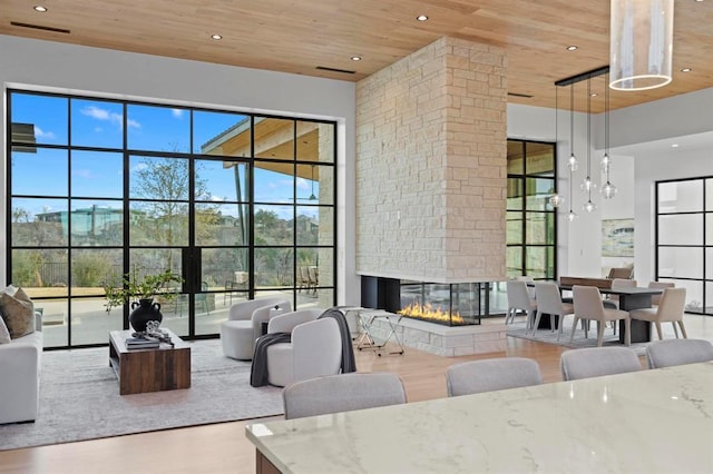 1047 Overlook Pkwy, Horseshoe Bay, TX 78657 - living area featuring wood ceiling, a towering ceiling, recessed lighting, a stone fireplace, and wood finished floors